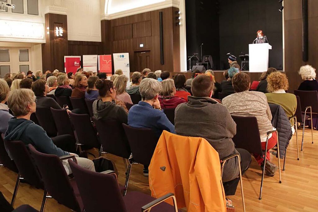 Eindrücke der Veranstaltung zum 8. März 2017 im Gewerkschaftshaus. Zu sehen sind Rednerinnen auf dem Podium und Gästinnen im Publikum.