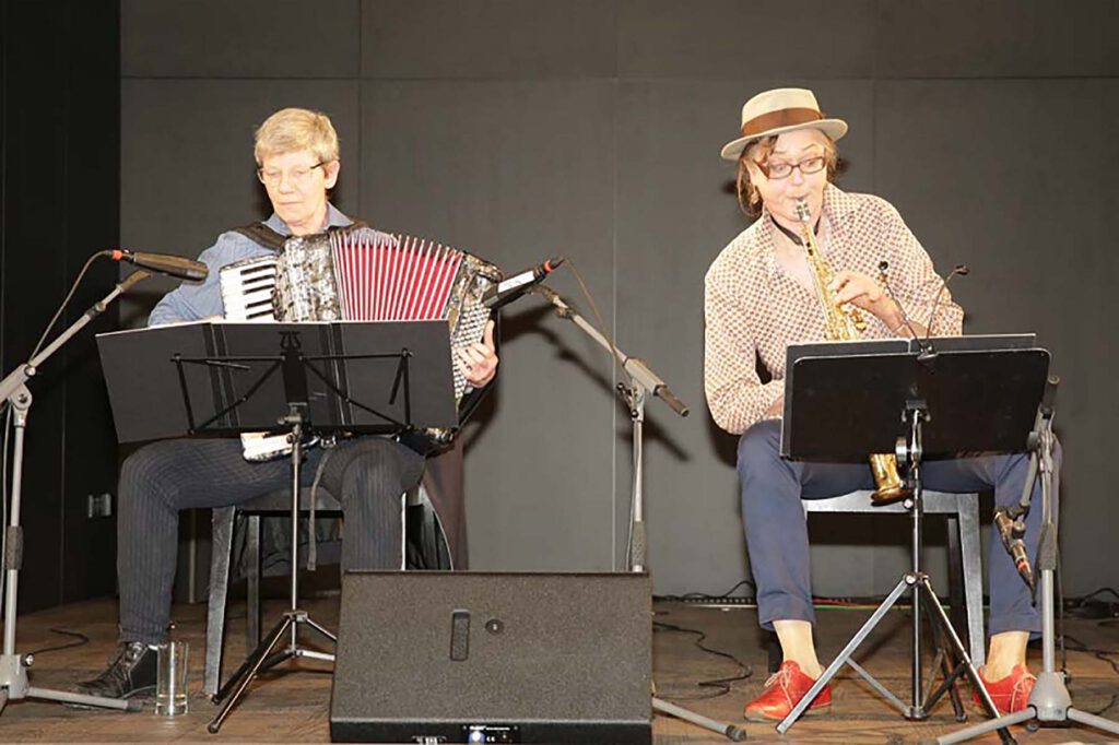 Eindrücke der Veranstaltung zum 8. März 2017 im Gewerkschaftshaus. Zu sehen sind Rednerinnen auf dem Podium und Gästinnen im Publikum.